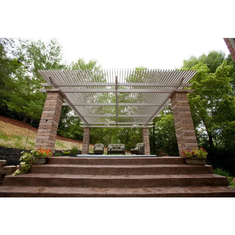 Wide shot of a custom metal roof structure on brick pillars covering an outdoor patio area.