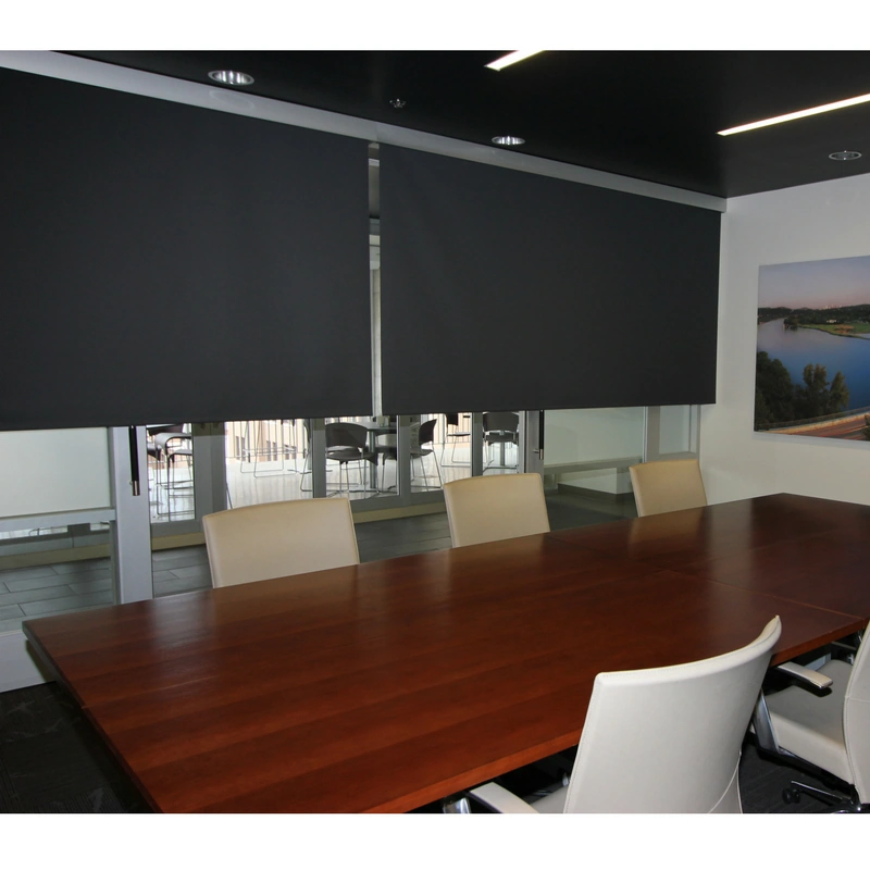 Black room darkening shades installed in a modern office space.