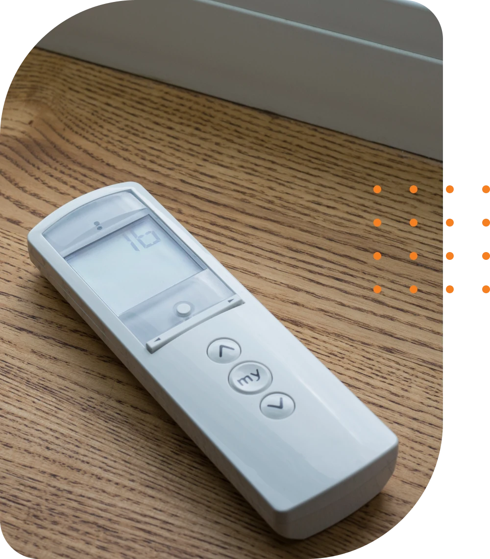 Shade automation remote laying on a wooden surface.