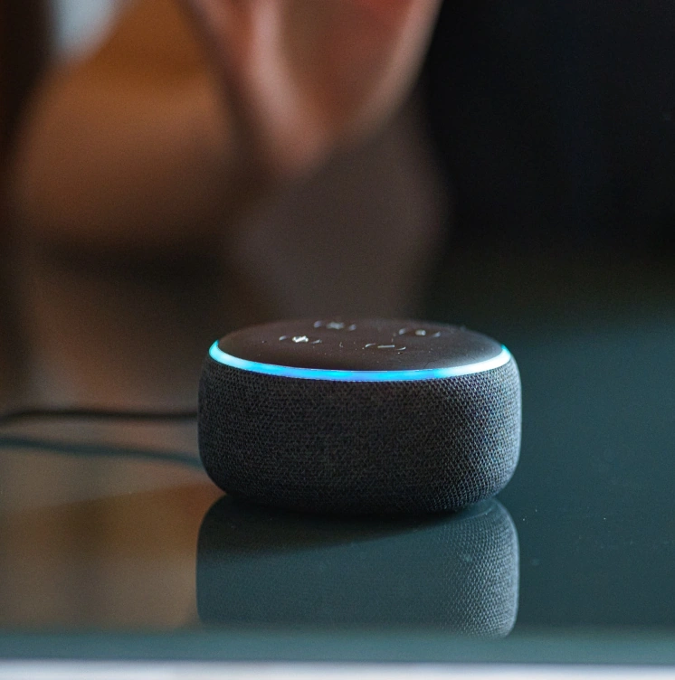 Amazon smart home device sitting on a glass tabletop.